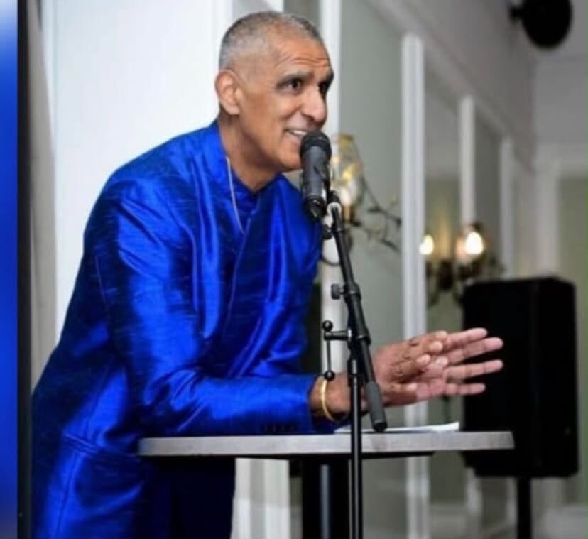 Kash speaking at a podium
